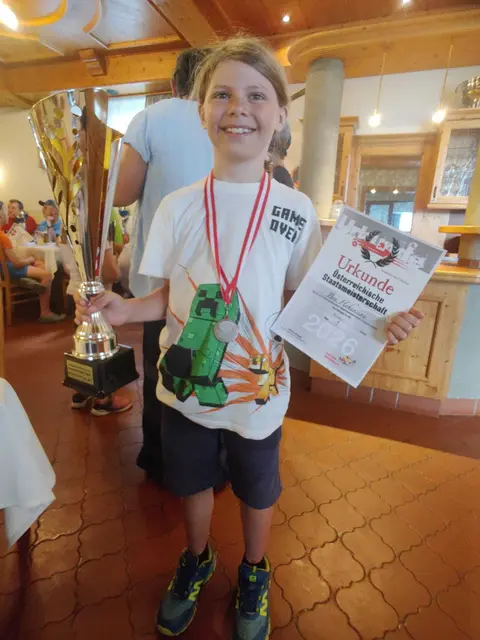 Ben Hohensinn strahlt mit dem Pokal um die Wette.