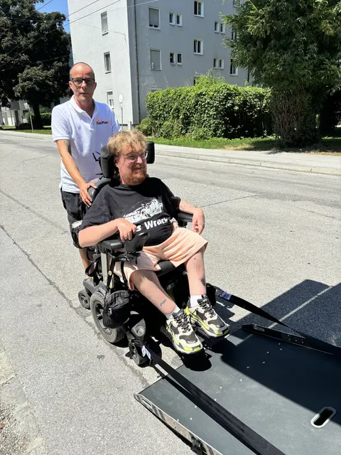 Seit Mai 2026 ist Raphael Grothe vorwiegend in und um Salzburg mit seinem barrierefreien Taxi unterwegs. Über eine Rampe kann er den E-Rollstuhl von Jasmin direkt ins Fahrzeug befördern. | Foto: Lisa Gold