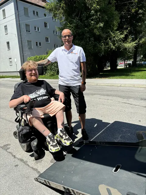 Seit Mai 2026 ist Raphael Grothe vorwiegend in und um Salzburg mit seinem barrierefreien Taxi unterwegs. Über eine Rampe kann er den E-Rollstuhl von Jasmin direkt ins Fahrzeug befördern. | Foto: Lisa Gold