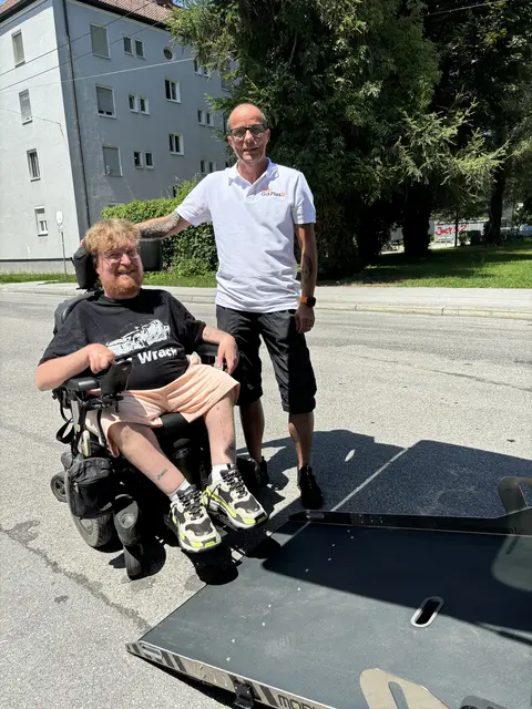 Seit Mai 2026 ist Raphael Grothe vorwiegend in und um Salzburg mit seinem barrierefreien Taxi unterwegs. Über eine Rampe kann er den E-Rollstuhl von Jasmin direkt ins Fahrzeug befördern. | Foto: Lisa Gold