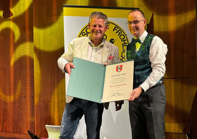 Bürgermeister Christian Scheider überreicht "Musikschule Fröhlich"-Leiter Adrian Holzer die "Dank und Anerkennung"-Urkunde. | Foto: Büro Bürgermeister