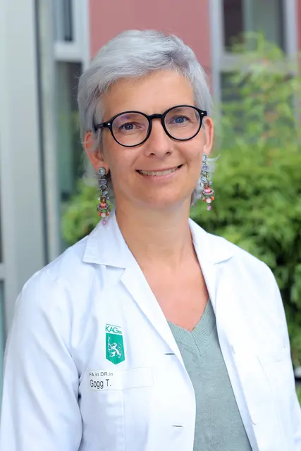 Frau mit kurzen Haaren und Brille