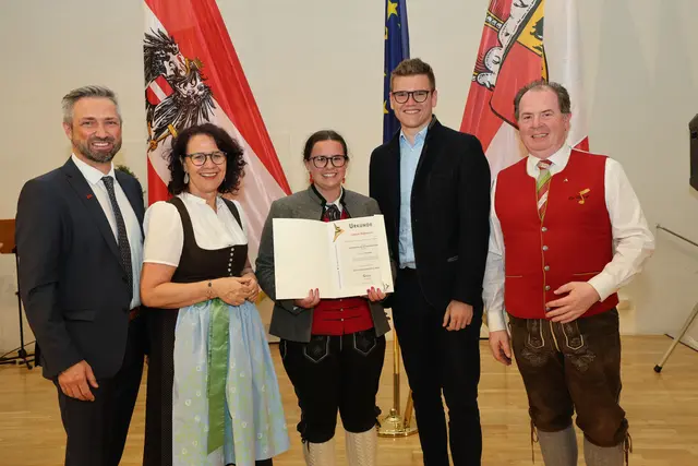 Bei der Übergabe der Urkunde an Larissa Roßmann aus St. Margarethen: Thomas Aichhorn (Direktor Musikum Salzburg) Landesrätin Daniela Gutschi, Larissa Roßmann, Landesrat Maximilian Aigner und Balthasar Gwechenberger (Landesobmann des Salzburger Blasmusikverbandes). (7. Juli 2026) | Foto: Land Salzburg / Franz Neumayr