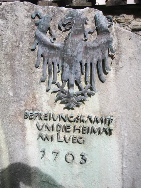 Historischer Gedenkstein aus Stein mit einem bronzenen Adler und eingravierter deutschsprachiger Inschrift im Außenbereich.