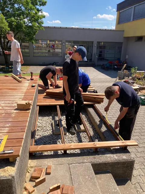 Schülerinnen und Schüler der MS St. Margarethen/Raab errichten gemeinsam mit "Technik für Kinder"-Mentor Johann Wagner (r.) das neue Aufenthalts- und Lernareal.