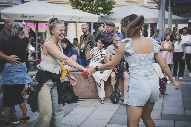 2 Frauen halten die Hand und tanzen