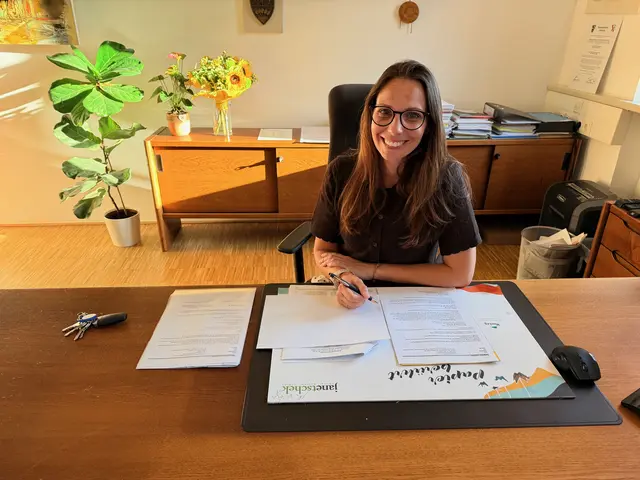 Bürgermeisterin Jasmin Klemmer-Schlögl sitz hinter ihrem Schreibtisch mit einigen Unterlagen vor ihr im Rathaus Purkersdorf.