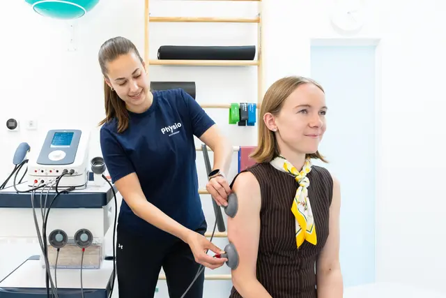 Eine Dame bekommt von einer Physiotherapeutin eine Behandlung.