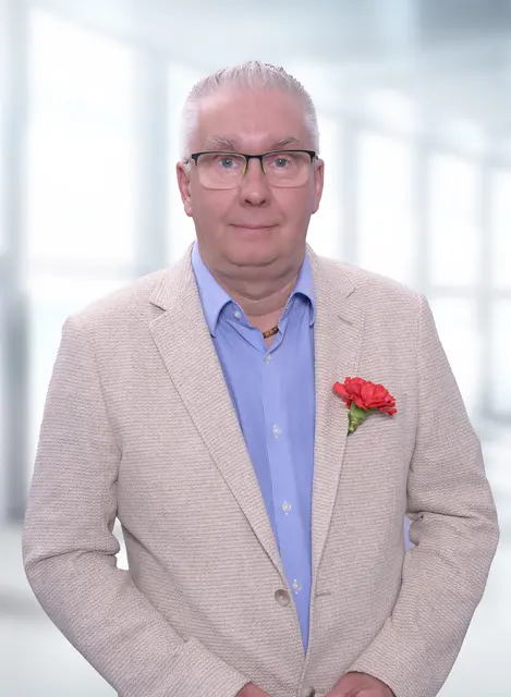 Ein Mann im Sakko mit einer roten Ansteck-Nelke