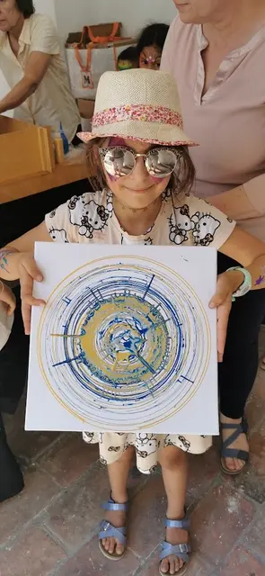 Ellie zeigt voll Stolz ihr Bild, gemalt mit der Farbschleuder. | Foto: Josef Messirek