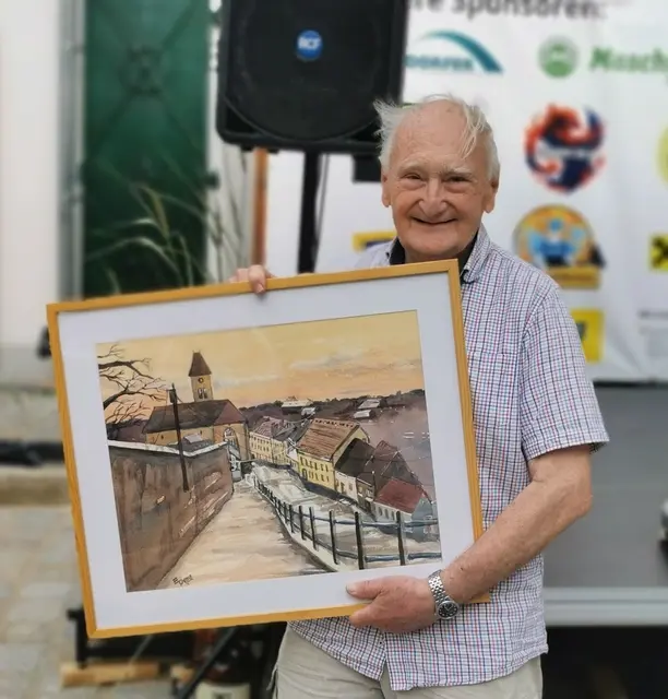 Herbert Puschnik hat Freude mit demTombolapreis, einem Bild von Erich Piffl. | Foto: Josef Messirek