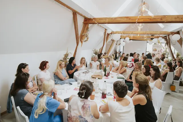 Frauen diskutieren an mehreren Tischen.