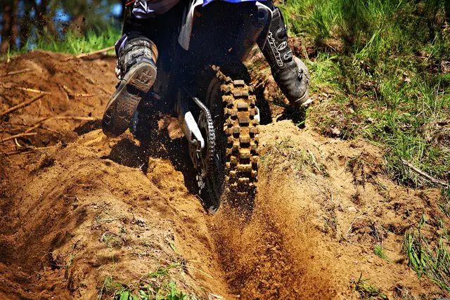 Hinterreifen einer Enduro-Maschine auf einem staubigen Weg