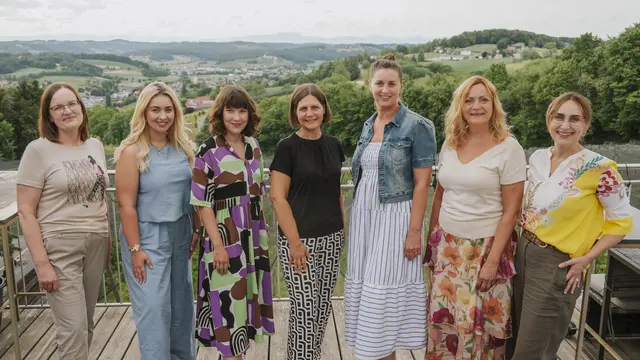 Eine Gruppe Frauen hat sich für ein Foto im Grünen positioniert.