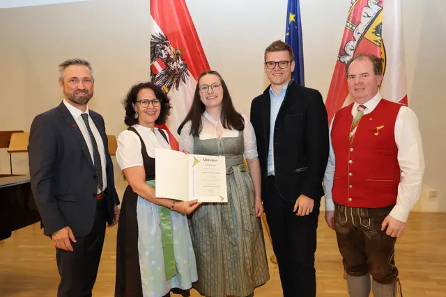 Bei der Übergabe der Urkunde an Isabella Krois aus St. Andrä: Thomas Aichhorn (Direktor Musikum Salzburg) Landesrätin Daniela Gutschi, Isabella Krois, Landesrat Maximilian Aigner und Balthasar Gwechenberger (Landesobmann des Salzburger Blasmusikverbandes). (7. Juli 2026) | Foto: Land Salzburg / Franz Neumayr