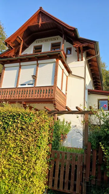 Eine weiß gefärbte Villa mit hellem Holzbalkon. LESCHETIZKY' steht in Großbuchstaben am Haus