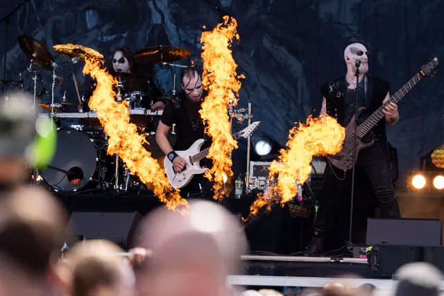 Eine Metalband spielt auf der Bühne und davor ein Flammenwerfer