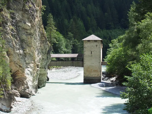 Landschaftsfotografie der historischen Burganlage Altfinstermünz, die sich tief unten auf dem Talboden einer engen, steilen und dicht bewaldeten Felsschlucht direkt am grünlichen Flusslauf des Inns befindet.