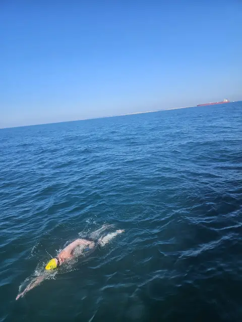 Liam Poberschnigg mitten im Ärmelkanal, runherum nur Wasser, hinten ein mächtige Schiff. Das Begleitboot war immer zur Stelle. | Foto: Team Poberschnigg