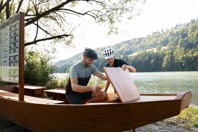 In einer Kiste auf einer Holzzille entdeckt das Paar gemeinsam einen Hinweis entlang der Penzensteinrunde des Escape Trails Neustift. | Foto: Tourismusverband Donau Oberösterreich/infilmity