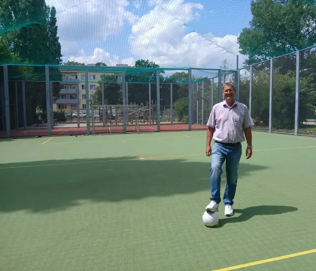 Bezirkschef Georg Papai (SPÖ) beim neuen leisen Bodenbelag des Ballspielkäfigs. | Foto: BV 21