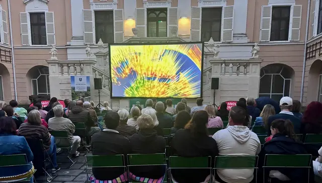Menschen sitzen vor einer Kinoleinwand