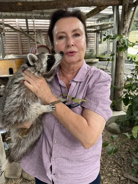 Frau Gabriele Wodak mit einem Waschbären