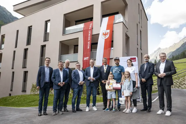 Großer Feiertag in Sölden-Kaisers: Vizebürgermeister Maximilian Riml, Bürgermeister Ernst Schöpf, Gemeinderat Makarius Fender, NHT-Geschäftsführer Markus Pollo, Landeshauptmann-Stv. Philip Wohlgemuth, Landtagspräsident Jakob Wolf, Dorfpfarrer Saji Joseph Kizhakkayil und NHT-Geschäftsführer Johannes Tratter begrüßen mit Familie Gavran die letzten Neuzugänge in der neuen Wohnanlage.   | Foto: NHT/Oss