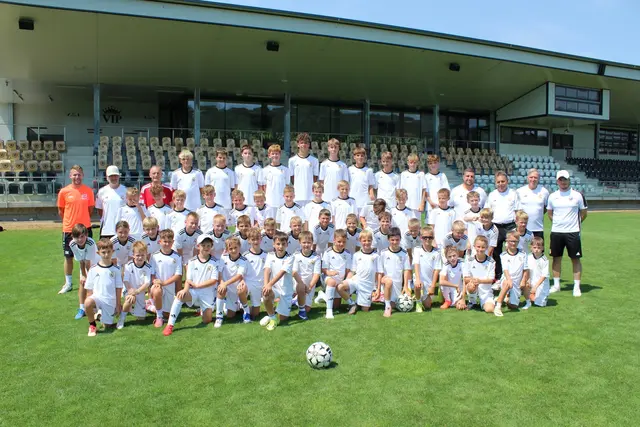 Eine große Gruppe junger Fusballerinnen und Fussballer haben sich für ein Foto aufgestellt.