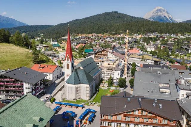Pfarrkirche und Klosterbräu sind seit jeher eng verbunden. Auch der Wiederaufbau des Fünfsternhauses schreitet gut voran. | Foto: Region Seefeld – Tirols Hochplateau