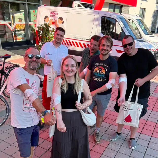 Eine gruppe von Menschen zeigen stolz ihre Arme.