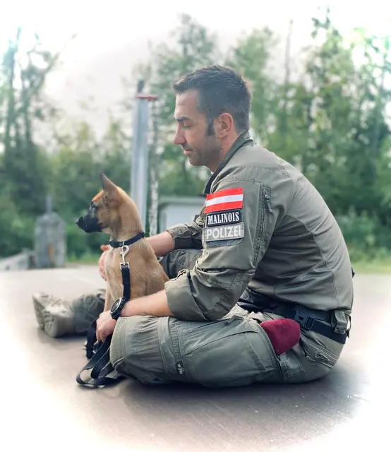 Markus Kovacs in Polizei-Dienstuniform mit jungem Malinois.