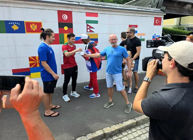 Initiator Ronny Ritter zeigt gemeinsam mit den Umsetzern aus aller Welt, wie die einzelnen Felder bemalt werden. | Foto: Marktgemeinde Tieschen