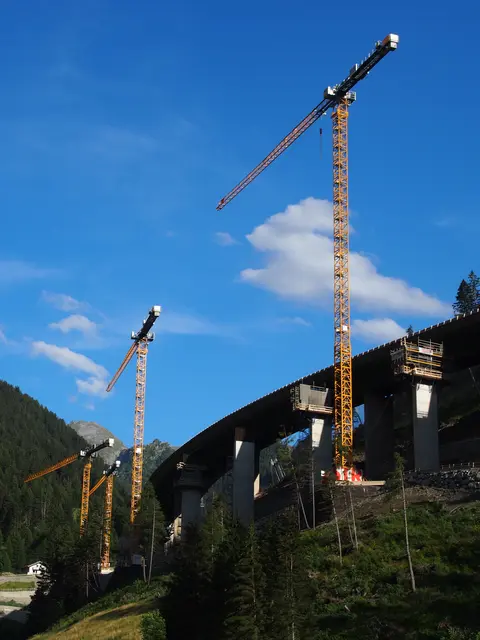 Transit damals und heute: Giganten in den Alpen: Wenn gelbe Riesenkräne die Bergkulisse überragen.