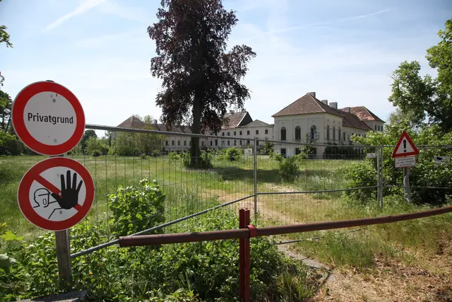 Schloss hinter Bauzaun und Verbotsschildern