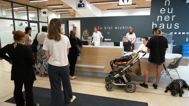 Mehrere Personen, teils in Begleitung von Sozialarbeiterinnen und -arbeitern, warten vor den Schaltern. | Foto: Andreas Pölzl/MeinBezirk