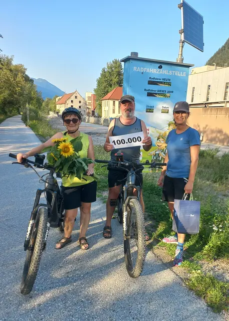 (v.l.) Gundi und Toni Haring aus Fügen wurden von Geir Sabine vom TVB Alpbachtal an der Brixlegger Zählstelle mit Blumen und Präsenten zum 100.000. gezählten Radfahrer überrascht. | Foto: Agerpress   