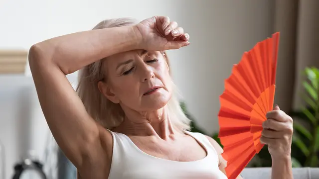 Frau mit Waage beim Abnehmen in den Wechseljahren