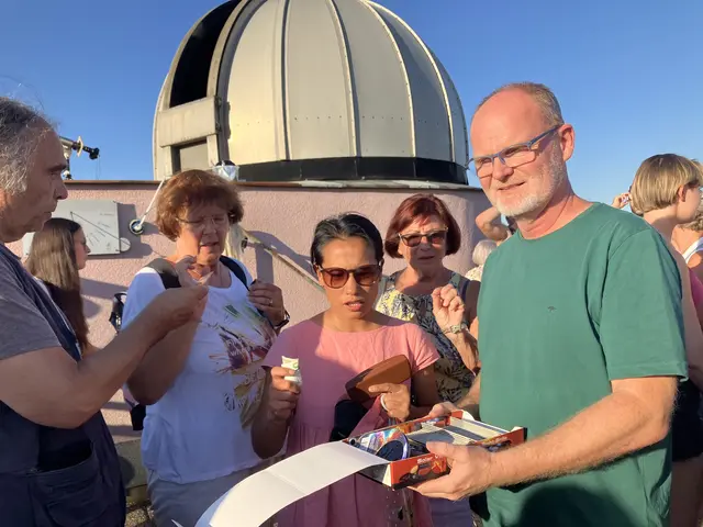 Robert Rentz verteilt die Brillen. Im Hintergrund die Kuppel der Sternwarte, unter der einige eindrucksvolle astronomische Geräte zu sehen sind | Foto: Stockmann