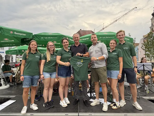 Brunnenthals Ortschef Roland Wohlmuth (Mitte) und Schärdings "Vize" Paul Königsberger (3. v. r.) in Vertretung von Stadtchef Günter Streicher, überreichten die Polos an die Jungmusiker.  | Foto: Jugendkapelle Schärding-Brunnenthal 