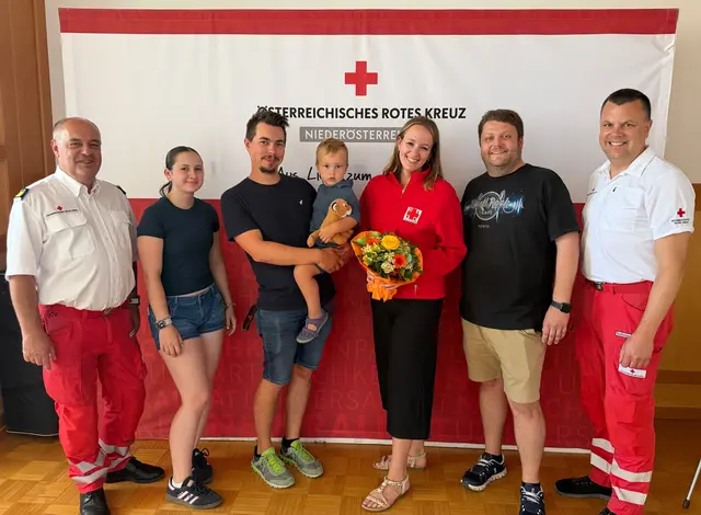 Katharina Hörmann-Dörr zusammen mit Mann Markus und ihrem Sohn sowie Bezirksstellenleiter Christian Hrauda, Jugendgruppenmitglied Tarja Oberbauer, Kurt-Jürgen Göbl und Bezirksstellengeschäftsführer Bernhard Schierer im Festsaal der Bezirksstelle zu sehen. | Foto: Rotes Kreuz