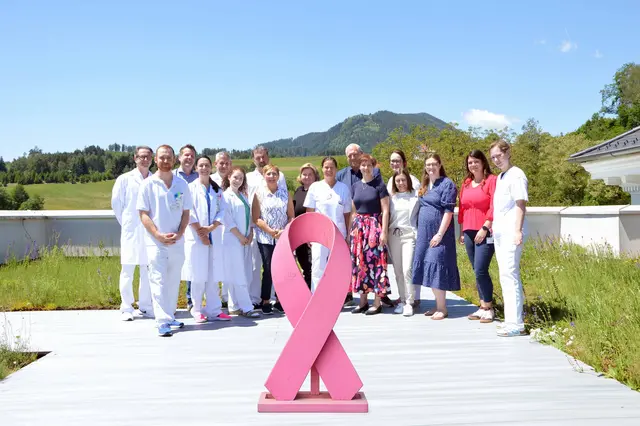 Das Team des Brustzentrums Kärnten mit den Fachgutachtern Oberärztin Dr. Kristina Schönau und DI Rainer Hartmann vor der Pink Ribbon-Schleife – dem internationalen Symbol für Brustkrebsaufklärung. Die Re-Zertifizierung des Brustzentrums bestätigt die Qualität der interdisziplinären Versorgung nach den Kriterien der DocZert. | Foto: Barmherzige Brüder