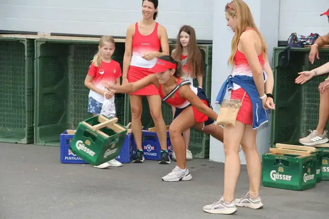 Einige Frauen in sportlicher Bekleidung feuern eine andere an, die gerade eine Bierkiste wirft.