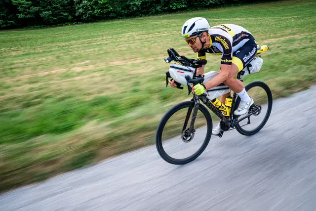 Ein Radfahrer fährt in hoher Geschwindigkeit auf einer Asphaltstraße
