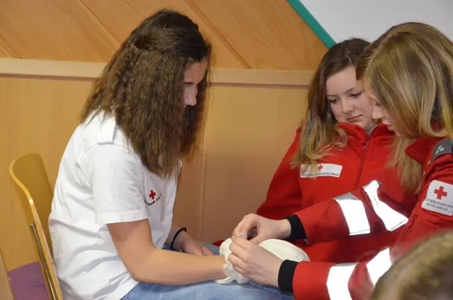 Eva-Maria zeigt wie man den Verband richtig anbringt. | Foto: Rotes Kreuz
