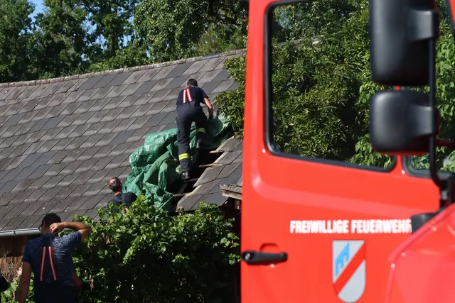 Das entstandene Loch im Dach wurde von den Einsatzkräften, darunter auch mehrere Dachdecker, provisorisch mit einer Plane abgedeckt. | Foto: laumat/Matthias Lauber