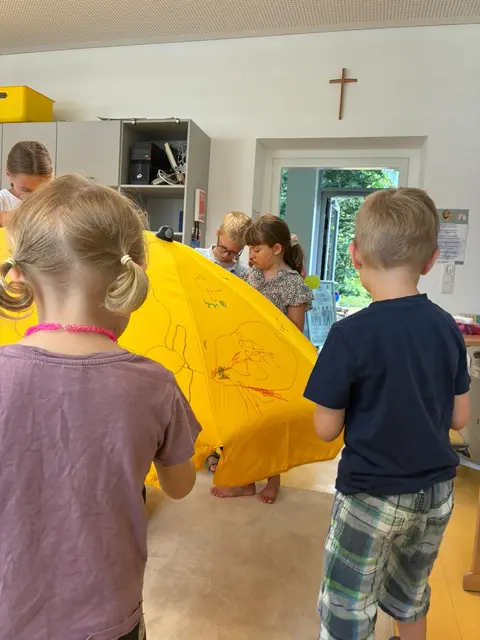 Kinder von doppler-Mitarbeitenden beim gemeinsamen Verzieren eines doppler-Sonnenschirms. | Foto: doppler