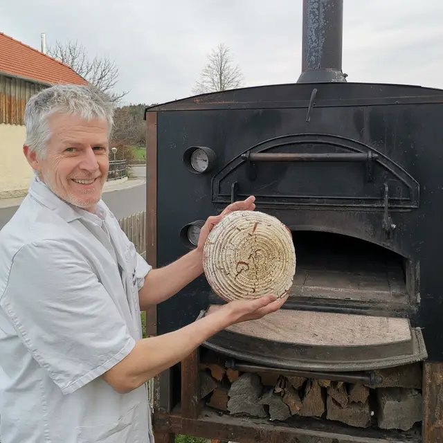 Bäckermeister Paul Strohmaier am Holzofen – eine große Version davon wird Mittelpunkt der neuen Backstube in Altenfelden.  | Foto: Ida Lösch
