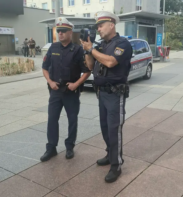 Jochen Trimmel und Michael Fucik von der Verkehrsinspektion mit dem Laser Messgerät in der Herzog-Leopold-Straße.