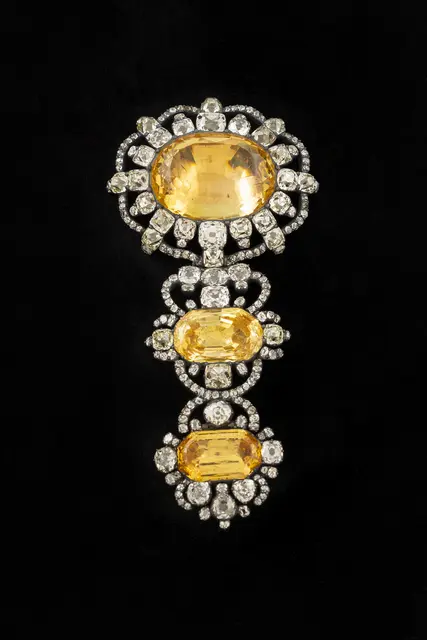 Unbekannter europäischer Goldschmied, „Hutnadel in den Farben des österreichischen Kaiserreichs“, 18. Jahrhundert. Silber, vergoldetes Silber beziehungsweise Gold, Diamanten und gelbe Saphire, 11,5 × 5,5 × 1,8 cm. Saint Joseph Trust. | Foto: MNBAQ, Louis Hébert